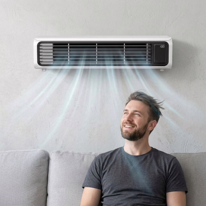 Ein Mann entspannt auf dem Sofa im Luftstrom eines an der Wand montierten FrostyLax Luftkühlers